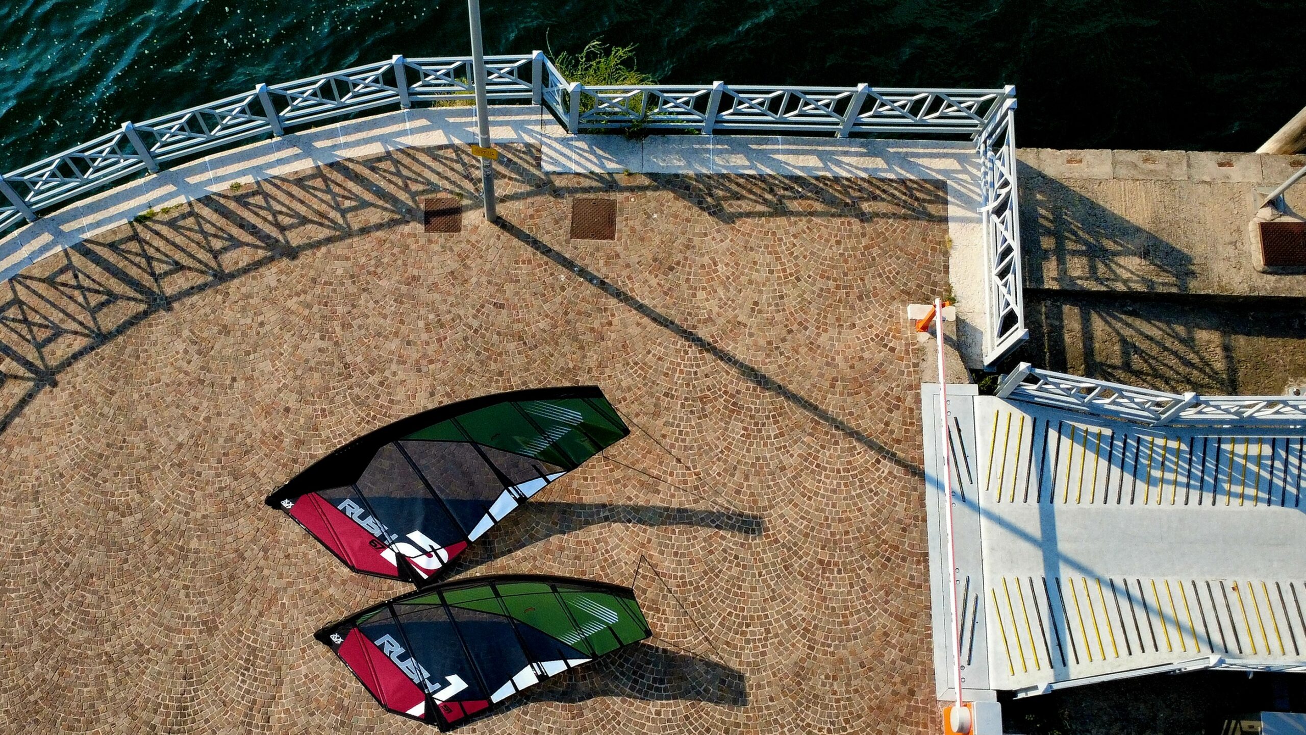 Aerial view of Rush-1 and Rush-2 sails rigged beside the water.