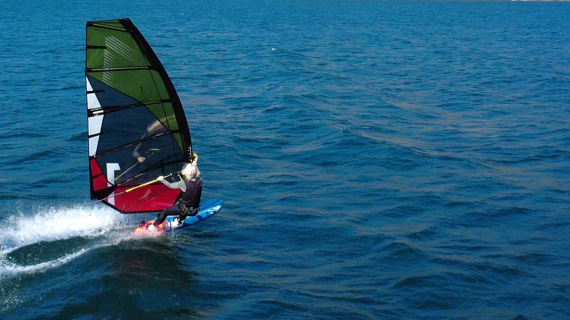 Rider sailing a Point-7 Rush rig across blue water.